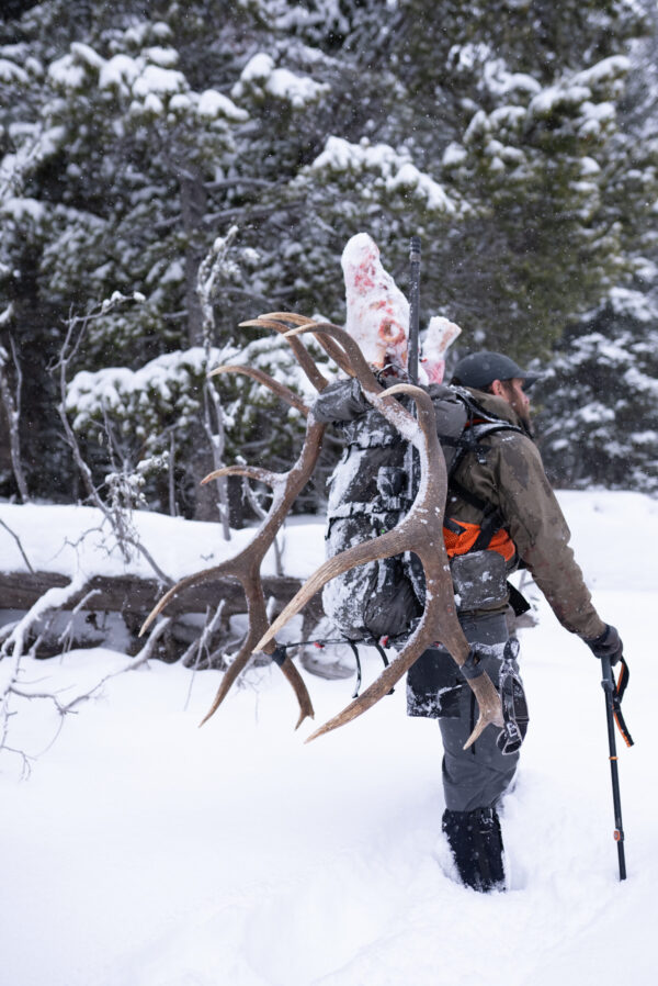 elk hunter wearing ape equipment hiking boot gaiters in snow